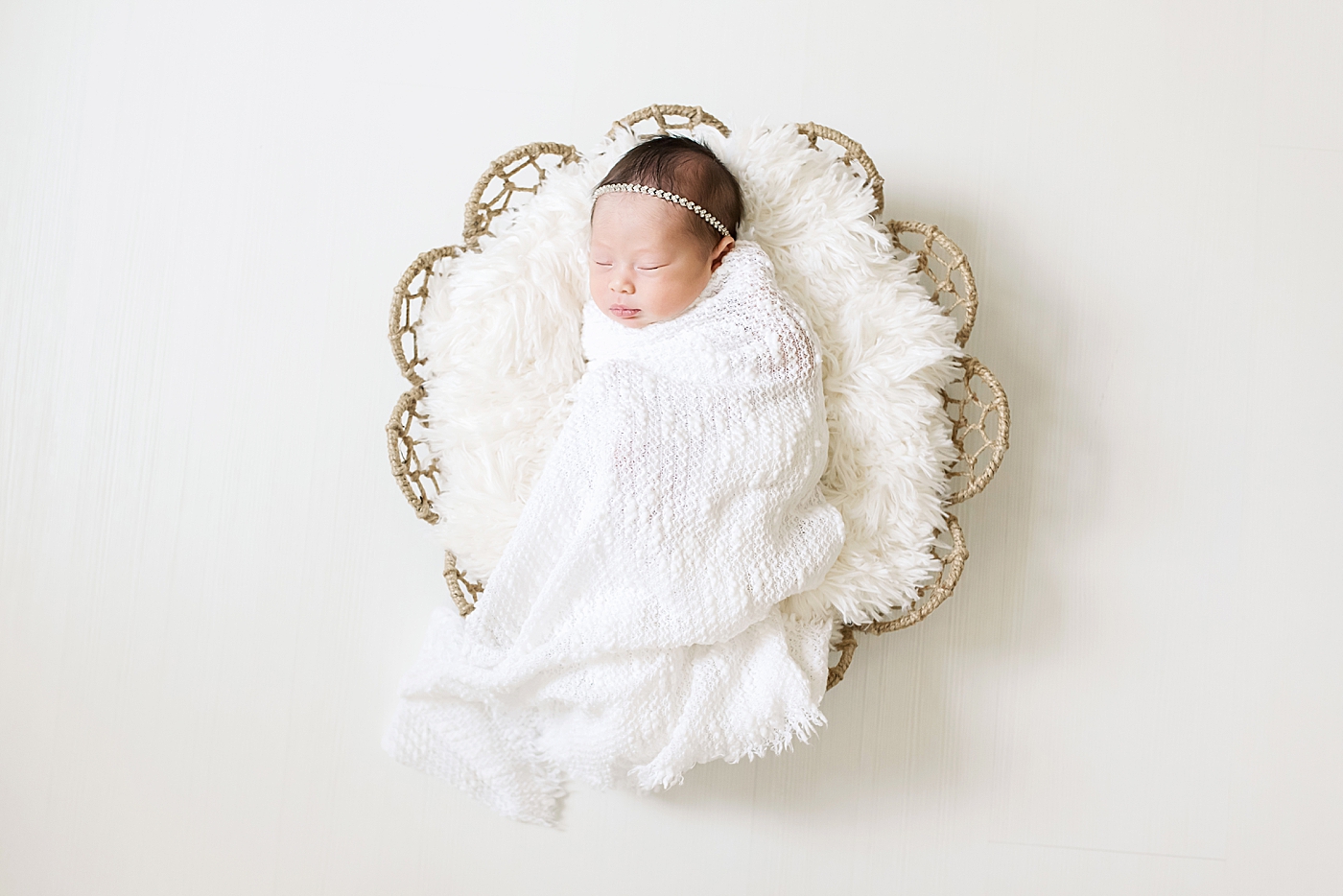 Newborn studio session for baby girl wrapped in white blanket | Photo by Anna Wisjo Photography