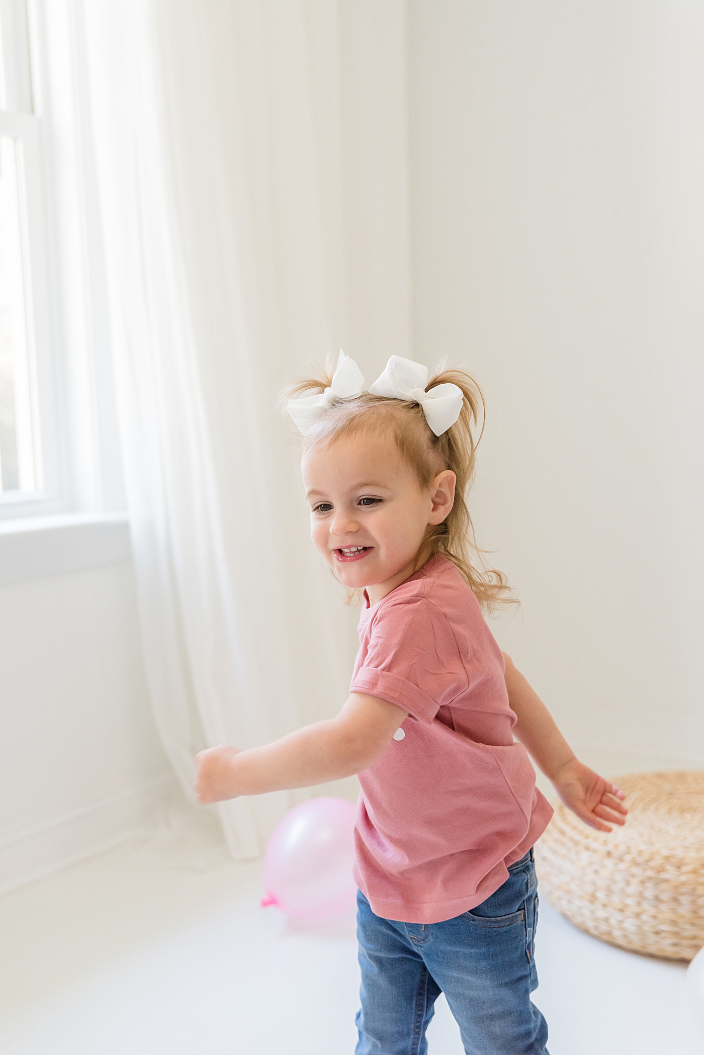 Little girl in a pink shirt twirling | Photo by Charlotte Milestone Photographer Anna Wisjo Photography
