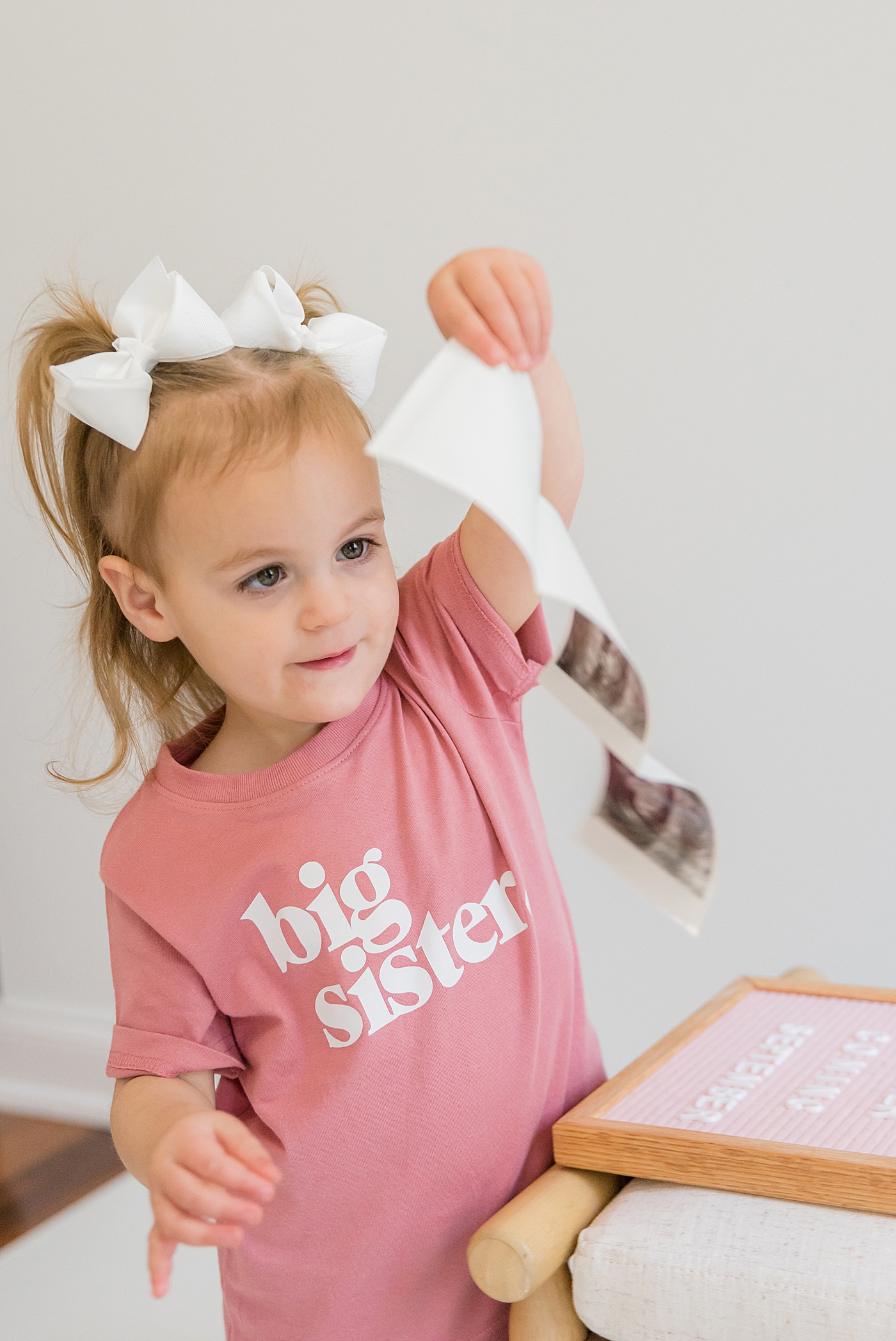 Little girl wearing a pink big sister shirt | Photo by Charlotte Milestone Photographer Anna Wisjo Photography