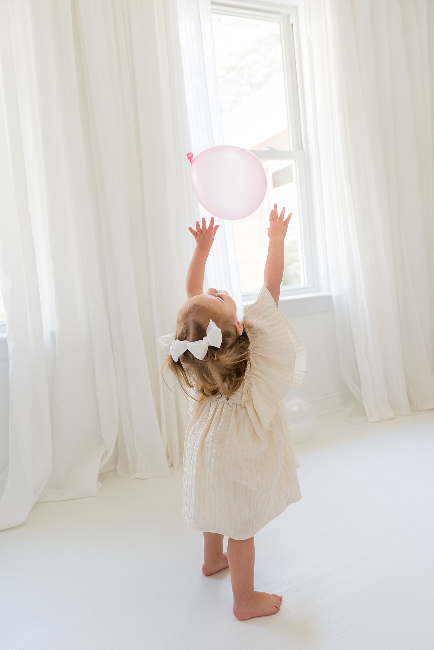 Little girl playing with balloons in the studio | Photo by Anna Wisjo Photography