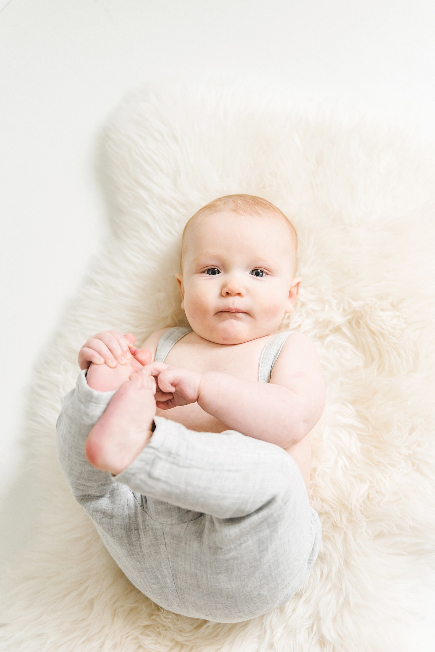 Blue eyed baby boy playing with his foot | Photo by Anna Wisjo Photography 