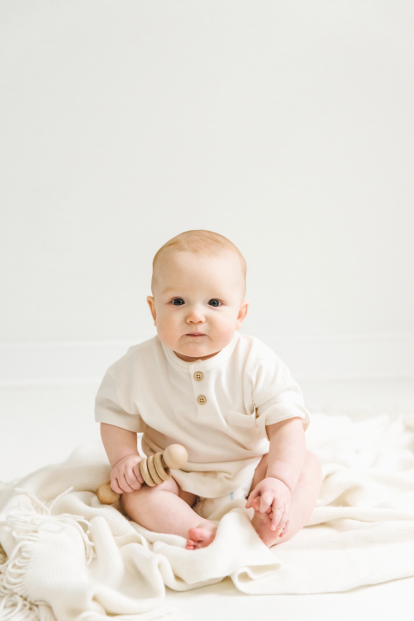 Baby boy in white during his studio session | Photo by Denver NC milestone photographer Anna Wisjo