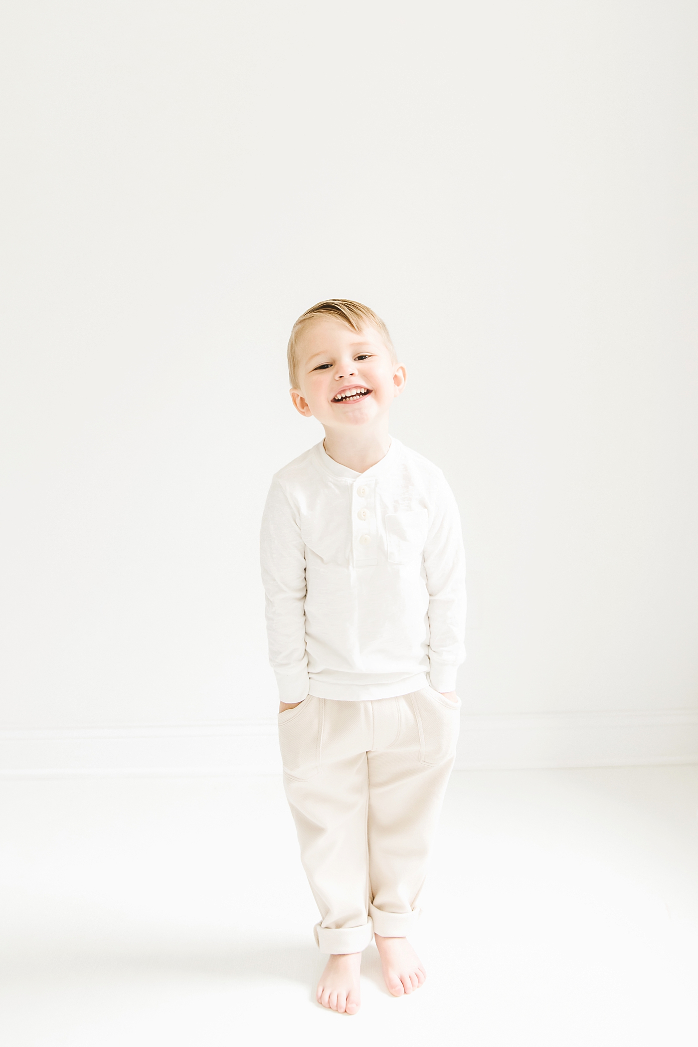 Little boy in white smiling | Photo by Denver NC milestone photographer Anna Wisjo