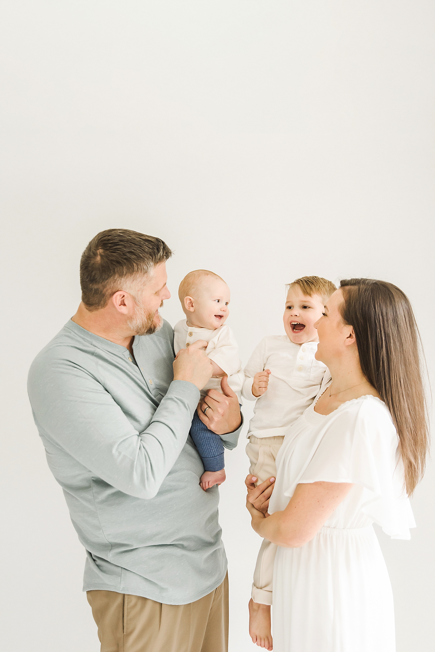 Family smiling together during their studio session | Photo by Denver NC milestone photographer Anna Wisjo
